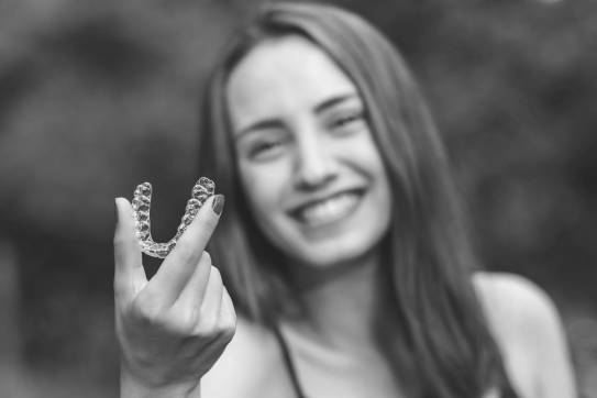 Patientin hält Zahnschiene in Hand