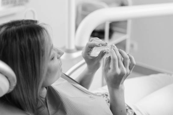 Patientin hält Zahnschiene in der Hand